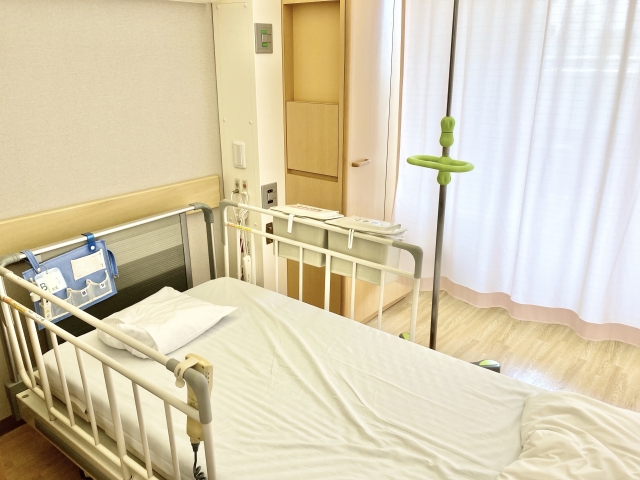病院の個室のベッドと点滴スタンド（イメージ）